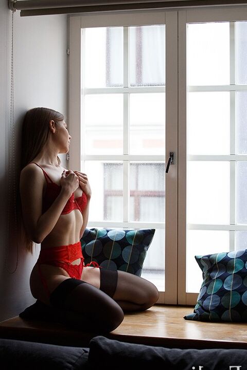 Evelina on the window in red lingerie